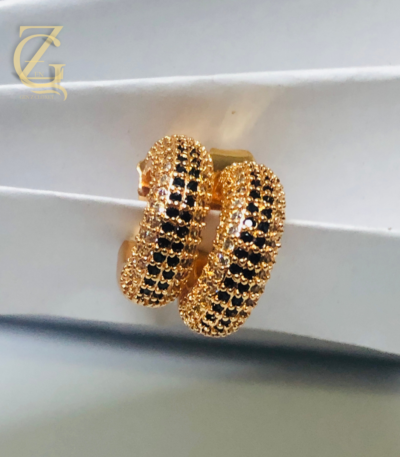 Add a touch of elegant sparkle to any look with these Gold Plated Ruby Crystal Huggi Hoop Earrings. Featuring deep ruby‑colored crystals set in gleaming gold‑plated hoops, they hug your ears comfortably while radiating rich, timeless charm — perfect for both everyday glam and special occasions.