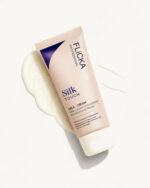 Flicka Silk Touch 3-in-1 Primer Moisturizer with SPF bottle on a clean, minimal white studio background.